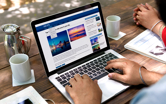 A person writing a blog post on a laptop