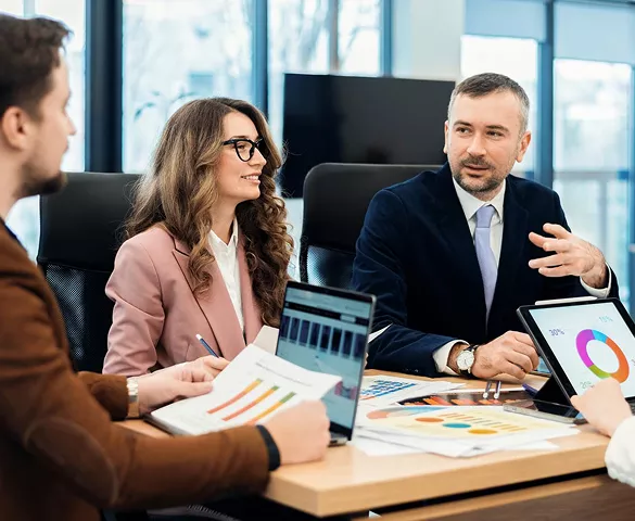 A sales team reviewing a visual sales pipeline on a large screen